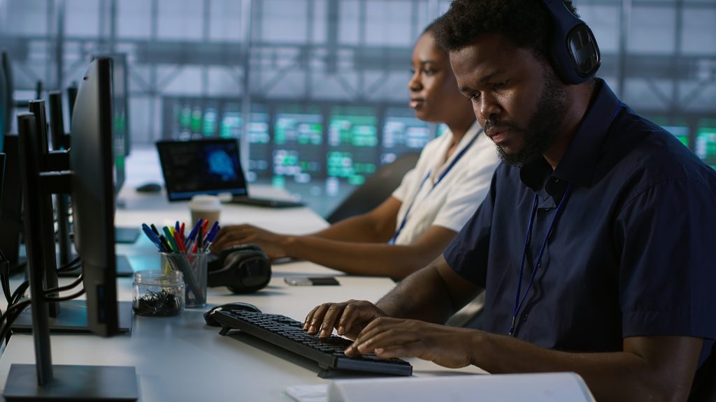 worker reading paperwork in data center, using analytics